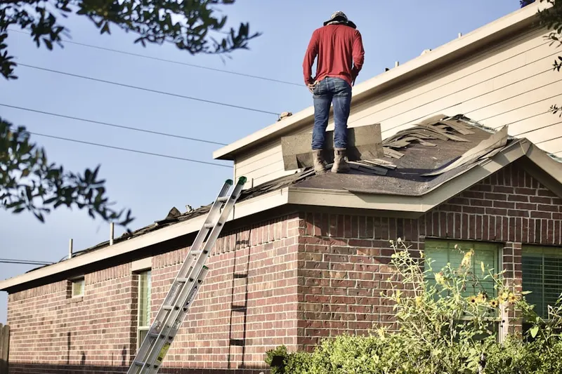 Professional roofer working on a residential roof in Hermon
